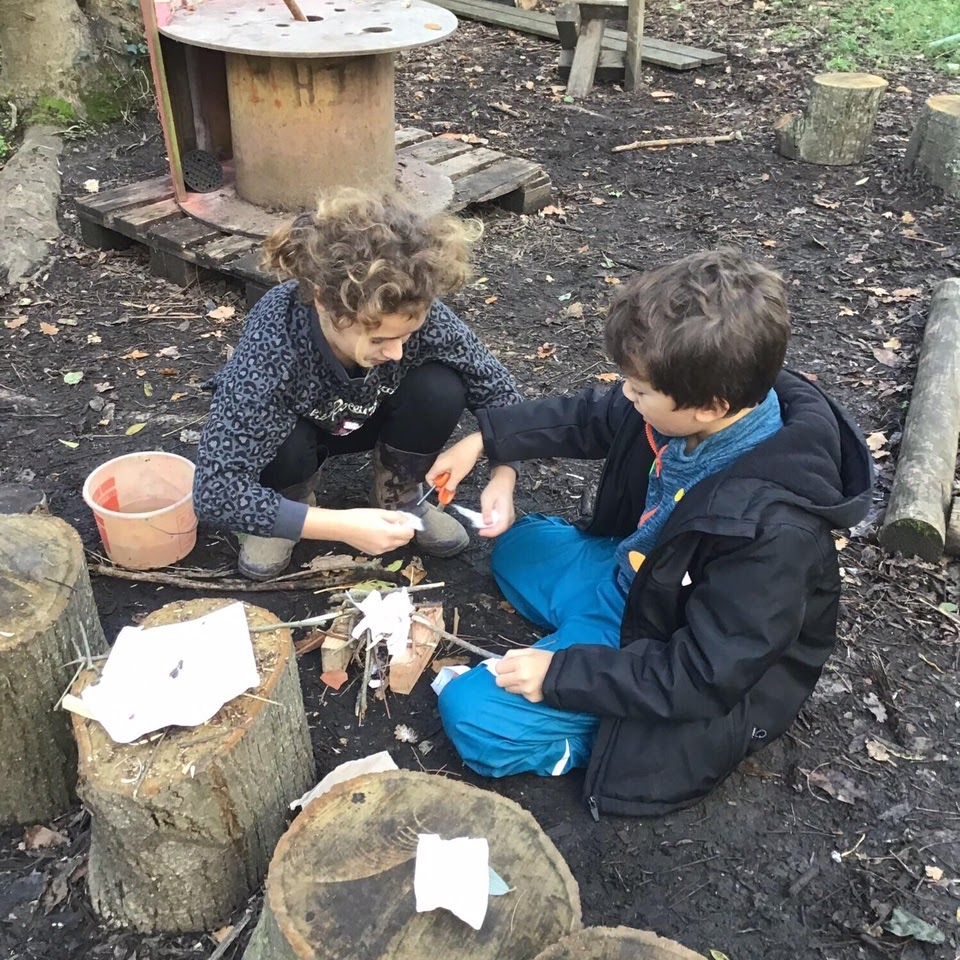 Two children building a campfire