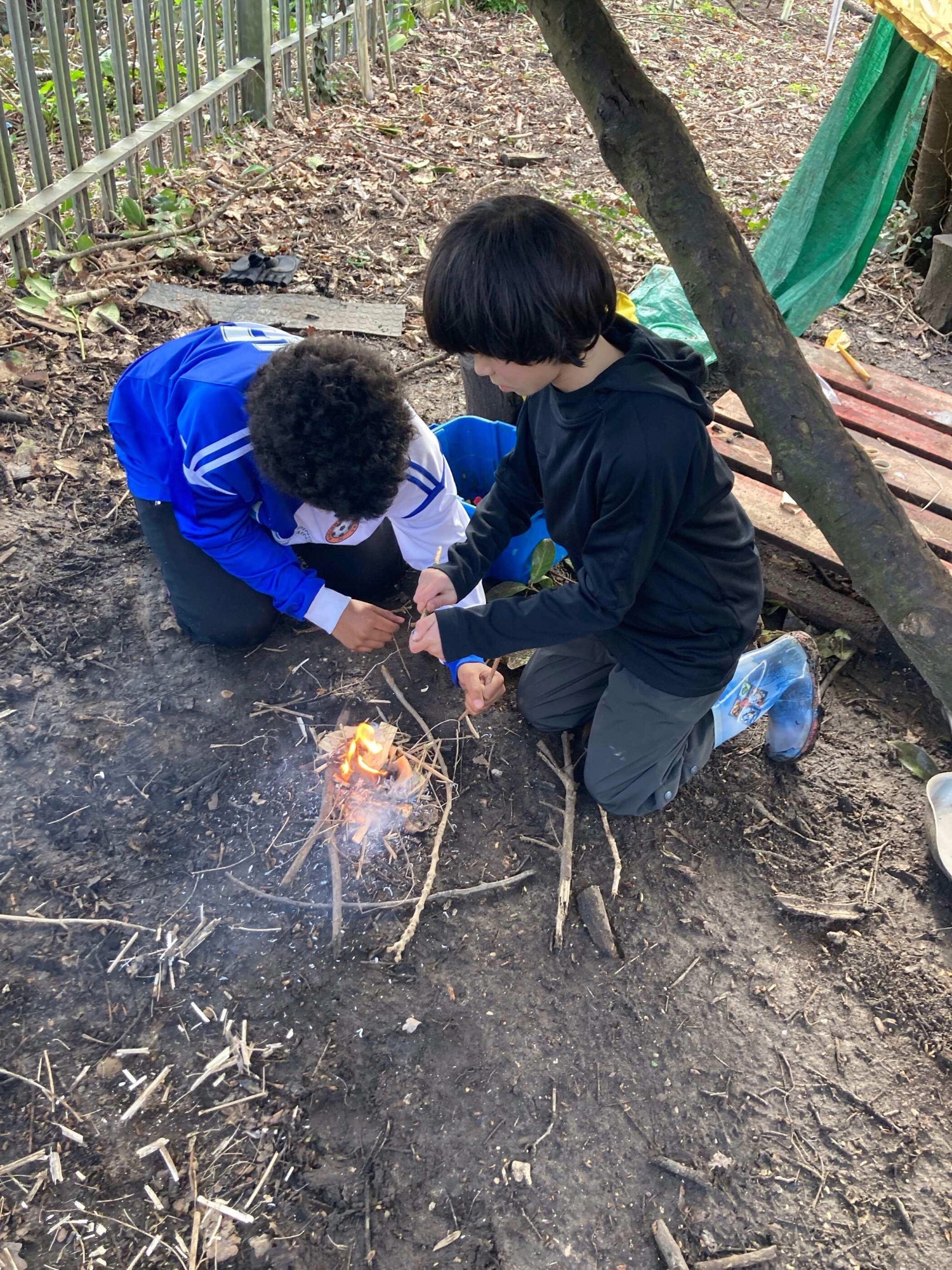 Two boys starting a fire